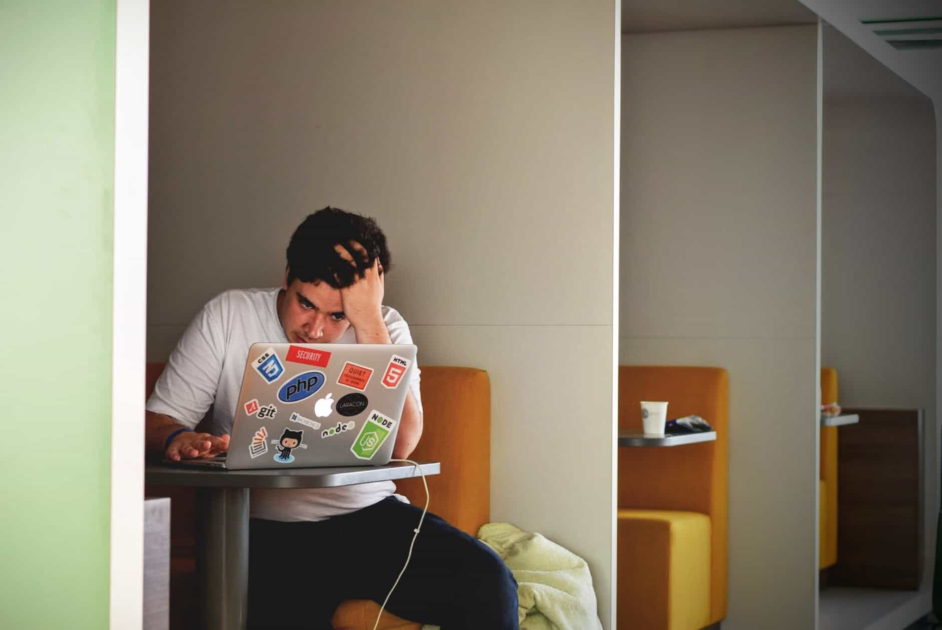 Man in white shirt using MacBook Pro